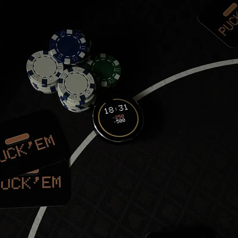 PUCK’em glowing on a poker table in a dim room beside chips and cards